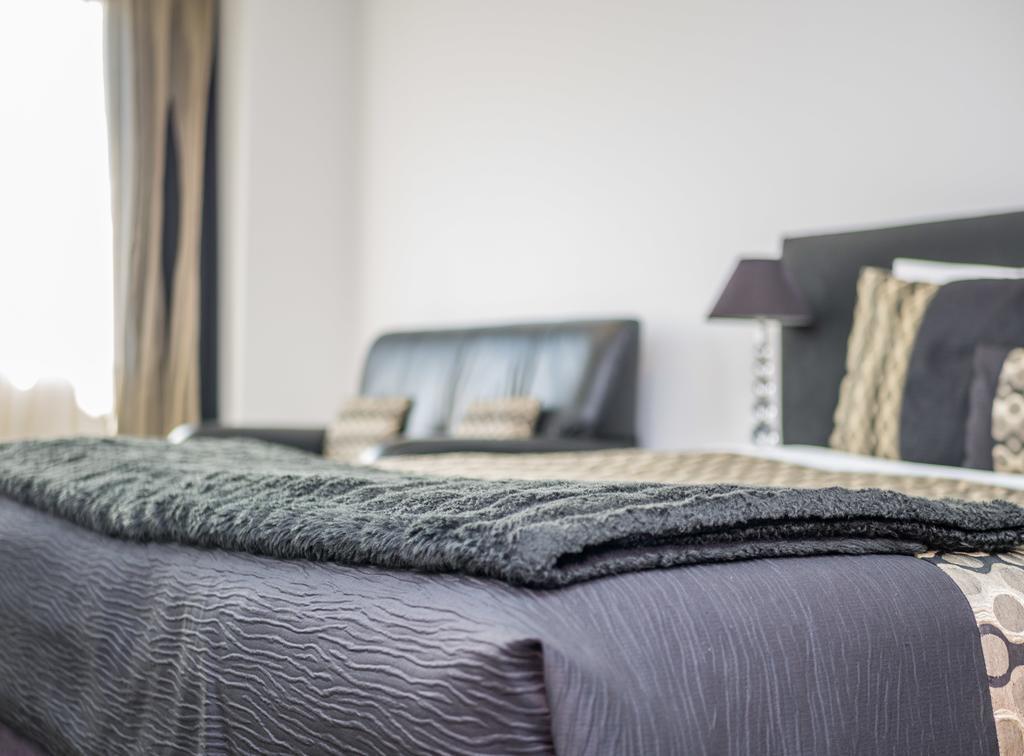 Bellano Motel Suites Christchurch Exteriör bild A bed with a throw