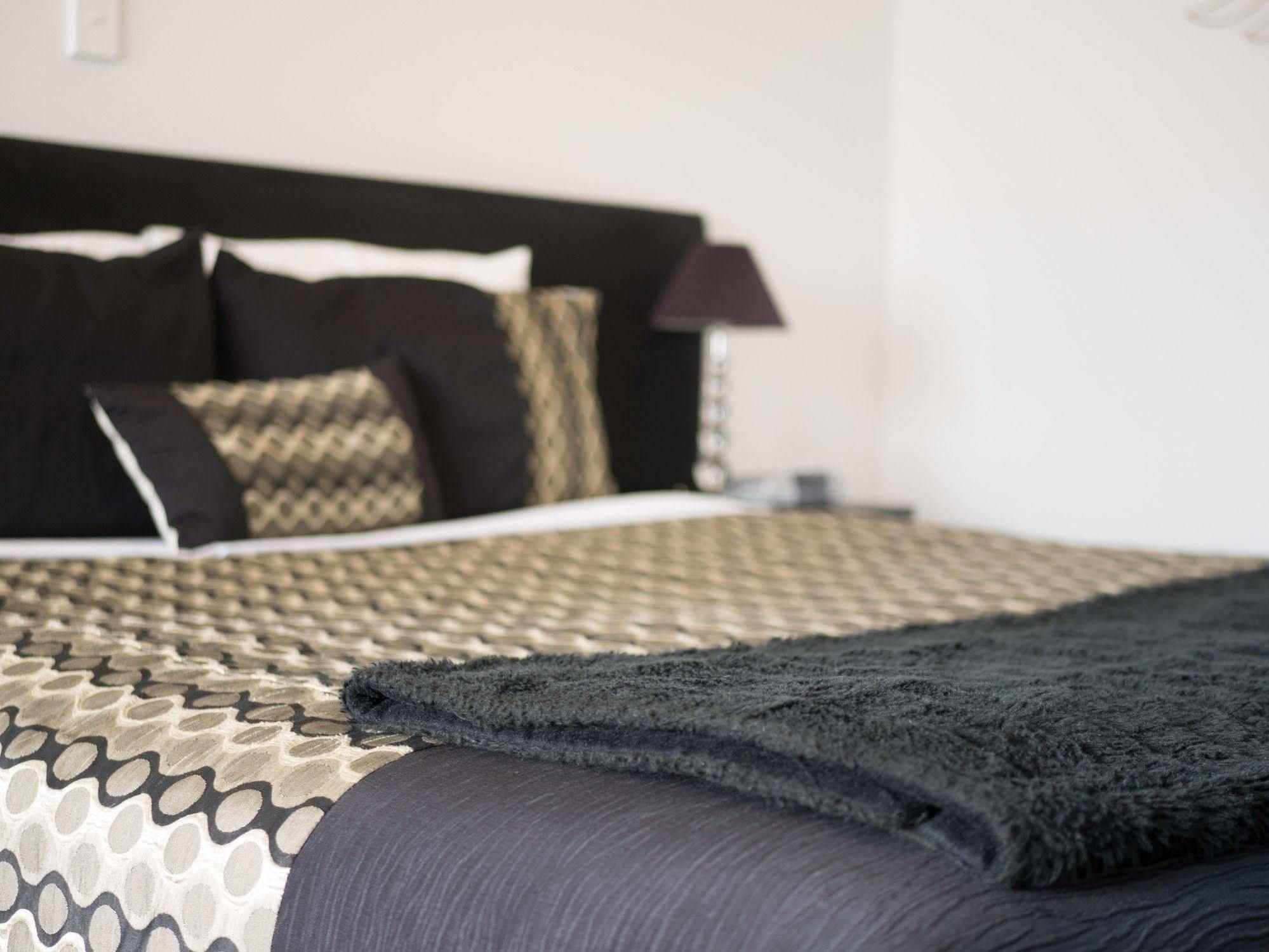 Bellano Motel Suites Christchurch Exteriör bild A bed with a throw